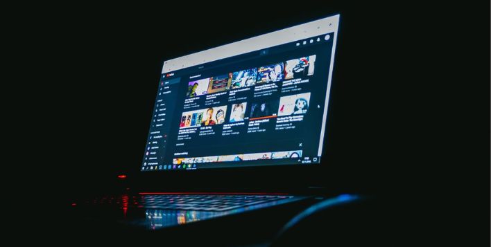 Imagen oscura de una laptop donde aparece la plataforma YouTube - SEO de YouTube.